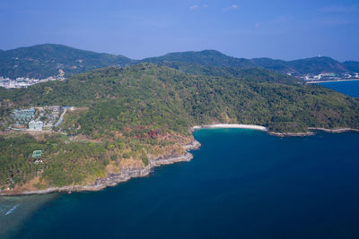 Scenic view of sea and mountains against blue sky