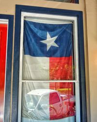 Close-up of flag against window