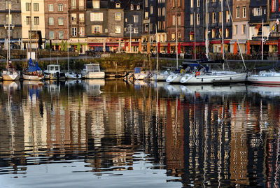 Boats moored in canal by buildings in city