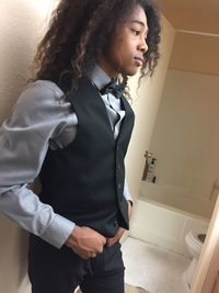 Well-dressed young man standing in bathroom at home