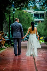 Rear view of friends standing on footpath