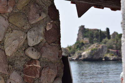 Close-up of rock by sea against sky