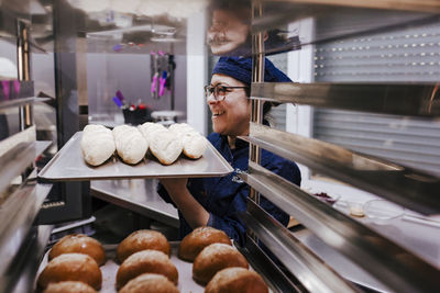 Woman holding food in tray at bakery