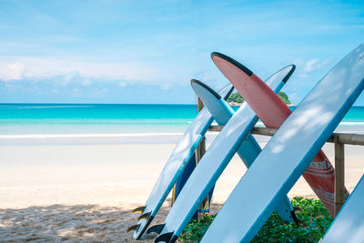 Deck chairs on beach against sky