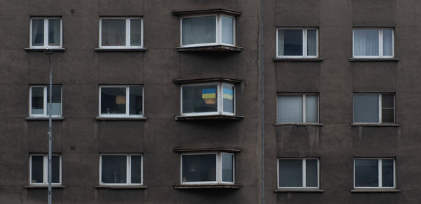 Ukrainian flag on residential building window.