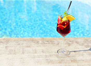 Close-up of drink on table against swimming pool