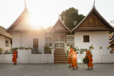 Rear view of people walking on temple against building