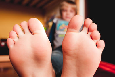 Little child lying on the wooden floor of his bedroom barefooted sensory connection concept