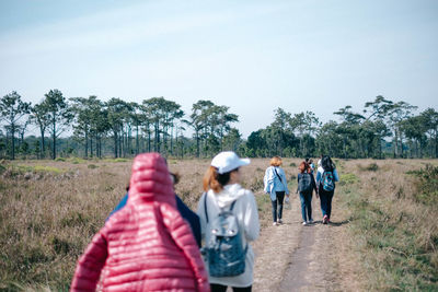 Rear view of people walking on road