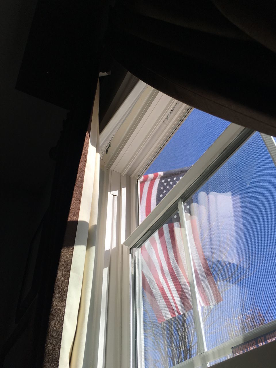 LOW ANGLE VIEW OF FLAGS HANGING AGAINST WINDOW