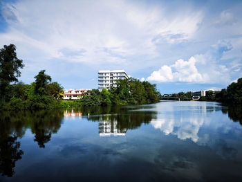 Scenic view of lake by buildings against sky