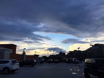 Cars on road against cloudy sky