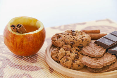 Close-up of apple and cookies with chocolates on table