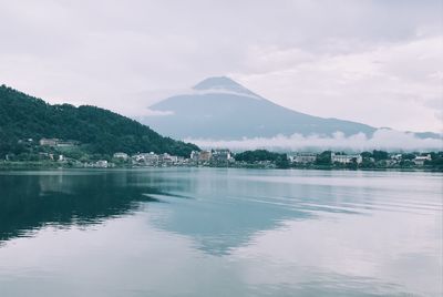 Scenic view of lake by mountains against sky