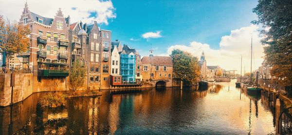 Bridge over river by buildings against sky in city