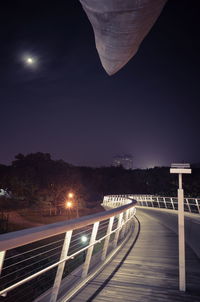 Illuminated bridge against sky at night