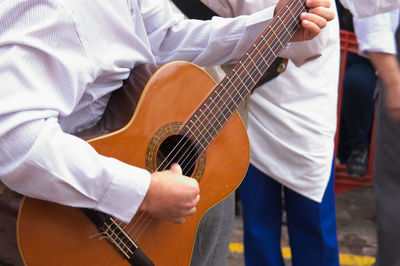 Midsection of man playing guitar