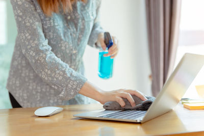 Woman using laptop on table at home