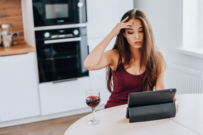 Young woman using mobile phone at home