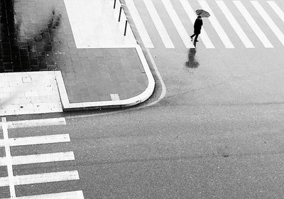 Low section of man walking on road in city