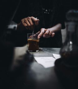Teo hands preparing a drink in dark tone