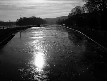 Wet road against sky during winter