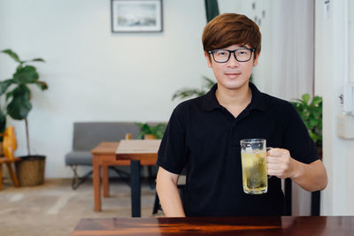 Portrait of young man making face on table