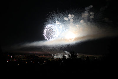 Low angle view of firework display at night