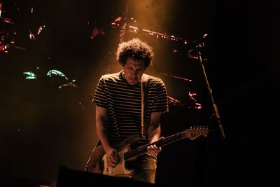 Man playing guitar at music concert