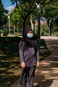 Young muslim woman wearing glasses and hijab head scarf and face mask.