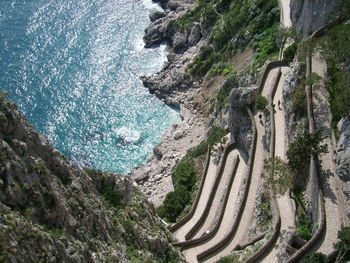 High angle view of road by sea against mountains