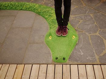 Low section of woman standing on footpath