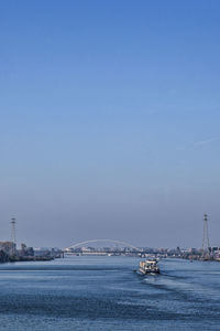 Cropped boat in river against clear blue sky