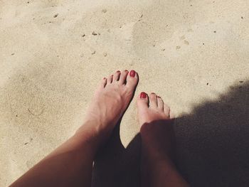 Low section of woman resting on sand