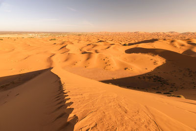 Scenic view of sand dunes in desert against sky