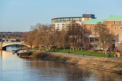 Buildings and trees in city against clear sky