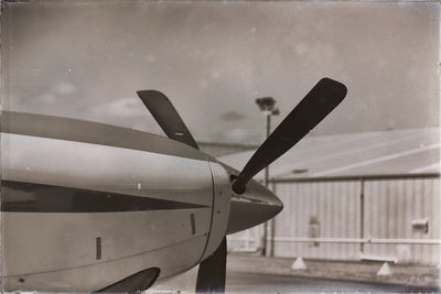 Close-up of airplane on airport runway against sky