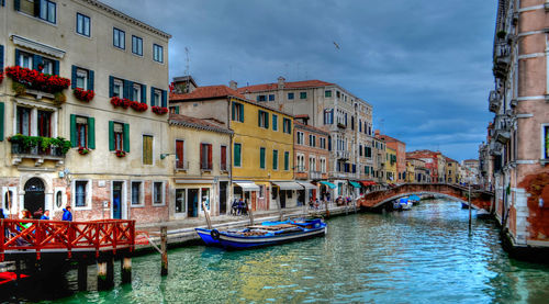 Boats in canal amidst buildings in city