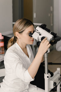 Side view of man photographing with camera