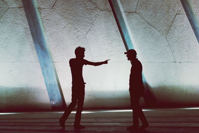 Side view of man standing against wall