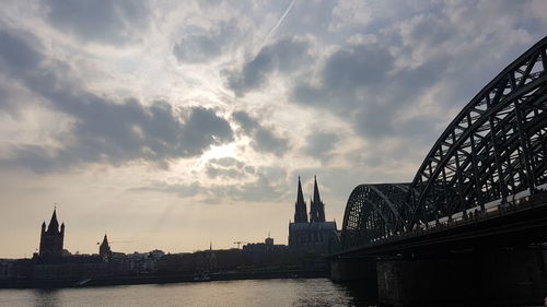 View of bridge over river against cloudy sky