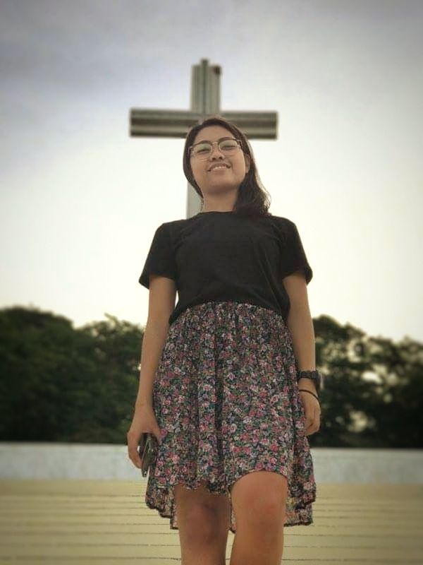 YOUNG WOMAN STANDING AGAINST SKY