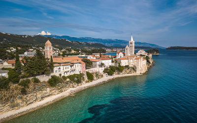 Buildings by sea against sky in city