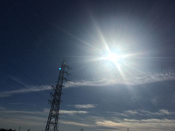 Low angle view of electricity pylon against sky during sunset