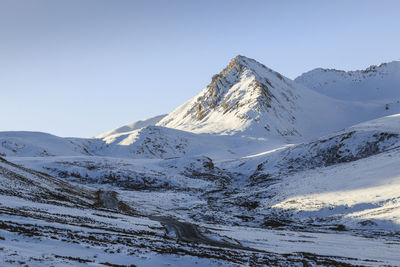 Scenic view of snowcapped mountains against clear sky