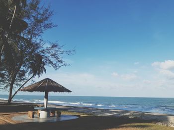 Lifeguard hut on beach against sky