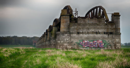 Old ruin on field against sky