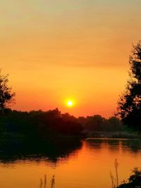 Scenic view of lake against orange sky