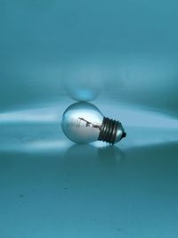 High angle view of light bulb on table against blue background