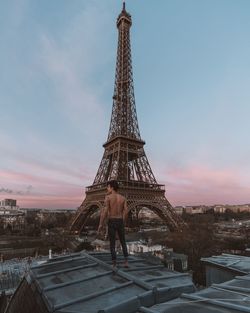 Rear view of man standing against eiffel tower